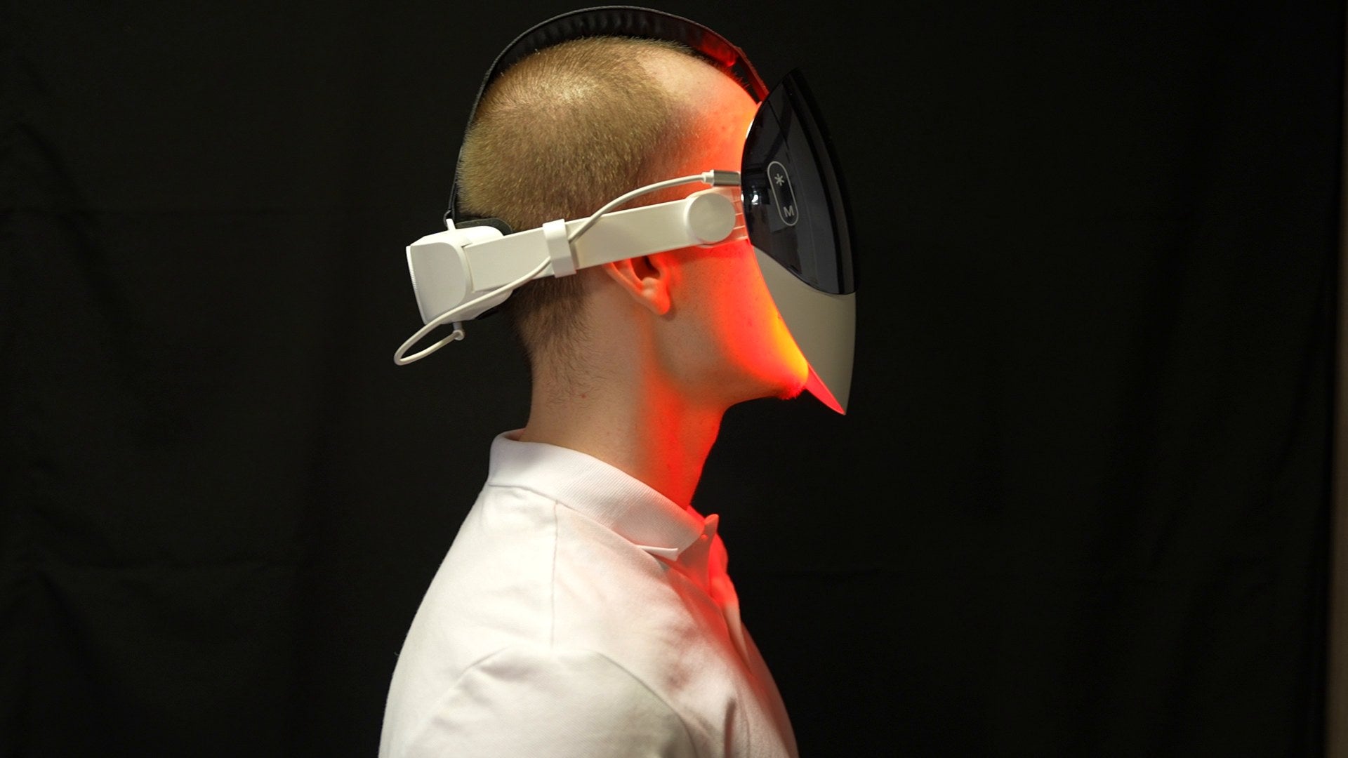 LED-masken under användning, från sidan, i rött ljus